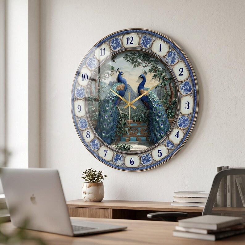 May include: A round wall clock featuring a central illustration of two peacocks facing each other amidst trees and a stone structure. The clock face has a blue and white floral patterned border with large, clear numbers from 1 to 12 and gold hands.