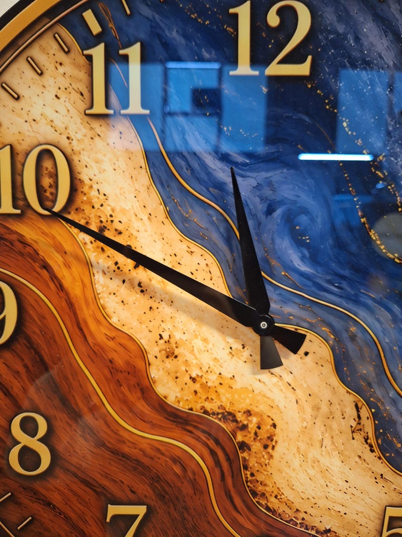 May include: A wall clock featuring a face with a swirling pattern of deep blue, tan, and dark brown wood grain textures. The clock has large gold-colored numerals from 7 to 12 and two thin black hands pointing toward the ten and twelve positions.