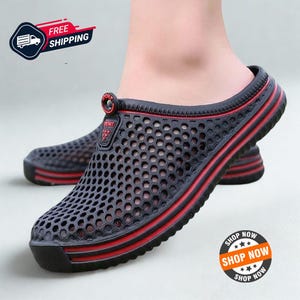May include: A black slip-on clog with a perforated honeycomb pattern across the upper. The shoe features red horizontal stripes along the sole and a small black tab on the top with the word SPORT printed in red lettering.