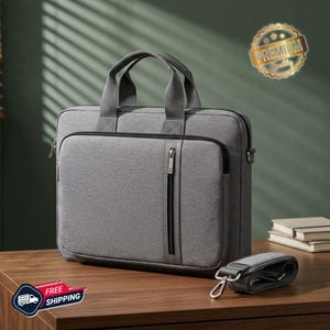 May include: A grey laptop briefcase featuring a rectangular shape, two top handles, and a vertical zippered front pocket. The bag includes a detachable shoulder strap with metal clips and a gold circular emblem reading Premium Quality.