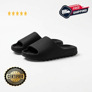May include: A pair of black slide sandals. The sandals have a simple, minimalist design with a thick sole and a single strap across the top of the foot. The sandals are made of a soft, rubbery material. The image also includes a "Certified" badge.