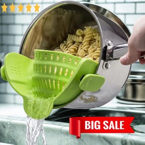 Pode incluir: Um coador de panela de silicone verde está preso a uma panela de aço inoxidável cheia de macarrão. A água escorre do coador. A imagem inclui uma faixa vermelha com as palavras "BIG SALE".