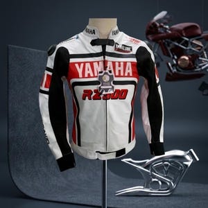 Könnte beinhalten: Weiß-schwarze und rote Yamaha RZ500 Motorrad-Rennjacke. Die Jacke hat das Yamaha-Logo und Sponsorenaufkleber. Die Jacke wird auf einer Schaufensterpuppe präsentiert, im Hintergrund ist ein Motorradrahmen zu sehen.