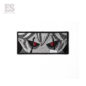 May include: Embroidered patch featuring a stylized anime-style face with red eyes and gray hair. The patch is rectangular with a black border and a white background. The eyes are the focal point, with a detailed design.
