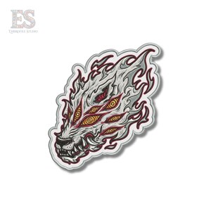 May include: Embroidered patch featuring a stylized wolf head with multiple eyes and a fiery mane. The design incorporates shades of white, red, and yellow, with intricate details. The patch is outlined in a light gray color.