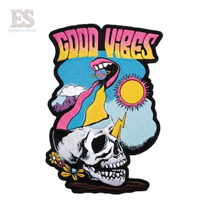 May include: An embroidered patch featuring a skull with an open top, from which a colorful stream flows into a mouth holding a planet. The text GOOD VIBES appears at the top in yellow and pink. A yellow sun, lightning bolt, and flowers are included.