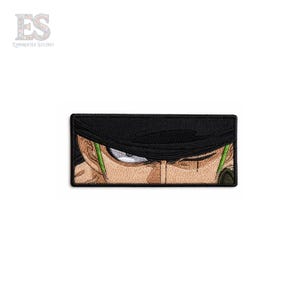 May include: A rectangular embroidered patch featuring a close-up of a character's eyes and forehead. The design includes a black bandana, tan skin tones, a visible scar, and bright green hair accents, all outlined with a thick black border.