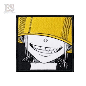 Può includere: Una toppa ricamata quadrata con un'illustrazione in bianco e nero di un personaggio con un ampio sorriso, che indossa un grande cappello giallo a secchiello che copre la parte superiore del viso, su uno sfondo nero.