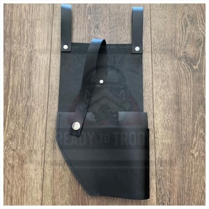Puede incluir: Cinturón utilitario de cuero negro con dos correas y un lazo, asegurado con remaches plateados. El cinturón presenta un bolsillo y el texto "READY TO TROOP" es visible.