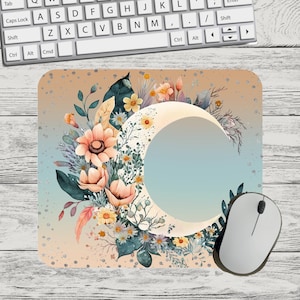 May include: A mouse pad with a crescent moon and floral design. The moon is white with a blue gradient inside. The flowers are pink, yellow, and white with green leaves. The background is a light peach color with silver glitter.
