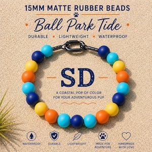 May include: A colorful dog collar made of 15mm matte rubber beads. The collar features a mix of blue, yellow, and orange beads, with the letters "SD" in the center. The text reads "Ball Park Tide" and "A coastal pop of color for your adventurous pup."