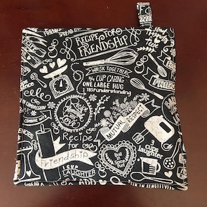 Puede incluir: Una taza de cerámica blanca con un asa negra y el texto "But First, Coffee" en un estilo manuscrito. La taza está sobre una superficie blanca. La taza mide 10 cm de alto.