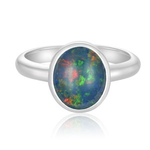 May include: A silver ring with an oval-shaped black opal gemstone. The opal has flashes of green, red, and blue.