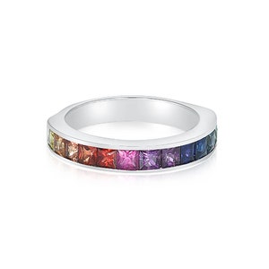 May include: A silver band ring with a rainbow of square-shaped gemstones set in a row.