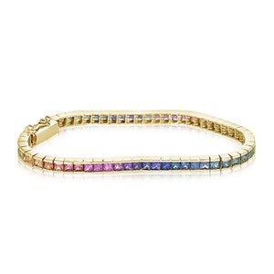 May include: A gold bracelet featuring a rainbow of square-shaped gemstones. The bracelet is crafted from 14k gold and features a total of 2.5 carats of sapphires.
