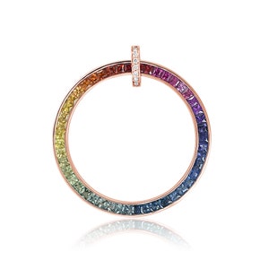 May include: A rose gold ring with a rainbow of sapphires set in a circle. The ring has a small diamond-encrusted bar in the center.