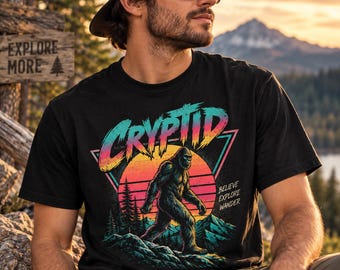 Maglietta grafica retrò anni '90 con Bigfoot e criptidi, design vintage con tramonto nella natura selvaggia (Comfort Colors)