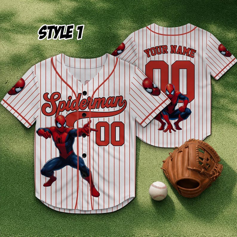 Może przedstawiać: Biała koszulka baseballowa z czerwonymi prążkami, z napisem "Spiderman" i numerem "00" w kolorze czerwonym. Koszulka ma grafikę Spidermana z przodu i z tyłu. Widoczna jest r&oacute;wnież rękawica i piłka do baseballu.