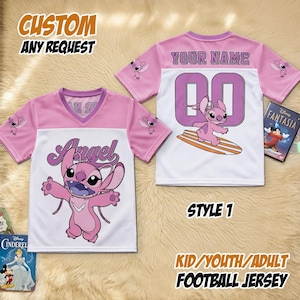 May include: Pink and white football jersey featuring the word "Angel" and a cartoon character on the front. The back displays "YOUR NAME" and the number "00". The jersey is labelled "STYLE 1" and "KID/YOUTH/ADULT FOOTBALL JERSEY".