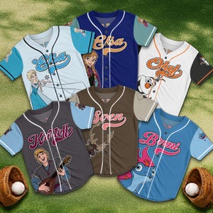 Könnte beinhalten: Eine Sammlung von Baseball-Trikots in verschiedenen Farben, die jeweils den Namen und das Bild eines Charakters aus einem beliebten Animationsfilm zeigen. Die Trikots umfassen Designs von Elsa, Olaf, Kristoff, Sven und Bruni, mit Baseballs und Handschuhen im Vordergrund.