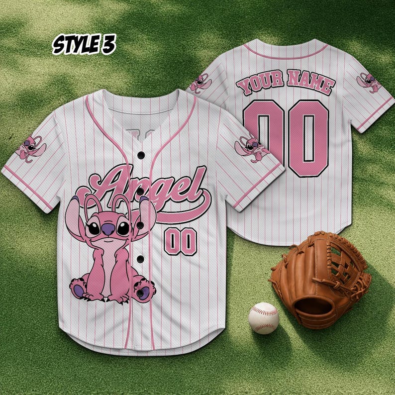May include: White baseball jersey with pink pinstripes, featuring a pink cartoon character and the word "Angel". The jersey has the number "00" and a baseball glove and ball are next to it.