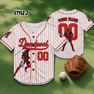 May include: White and red pinstripe baseball jersey with "Deadpool" and "00" in red. A Deadpool graphic is on the front. A baseball glove and ball are next to the jersey. The jersey is style 2.
