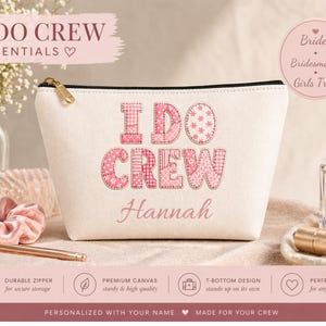 Puede incluir: Bolsa de cosméticos de lona blanca con el texto "I DO CREW" en letras de patchwork rosas. La bolsa tiene una cremallera dorada y el nombre "Hannah" en cursiva. Diseñada para novias, damas de honor y viajes de chicas.