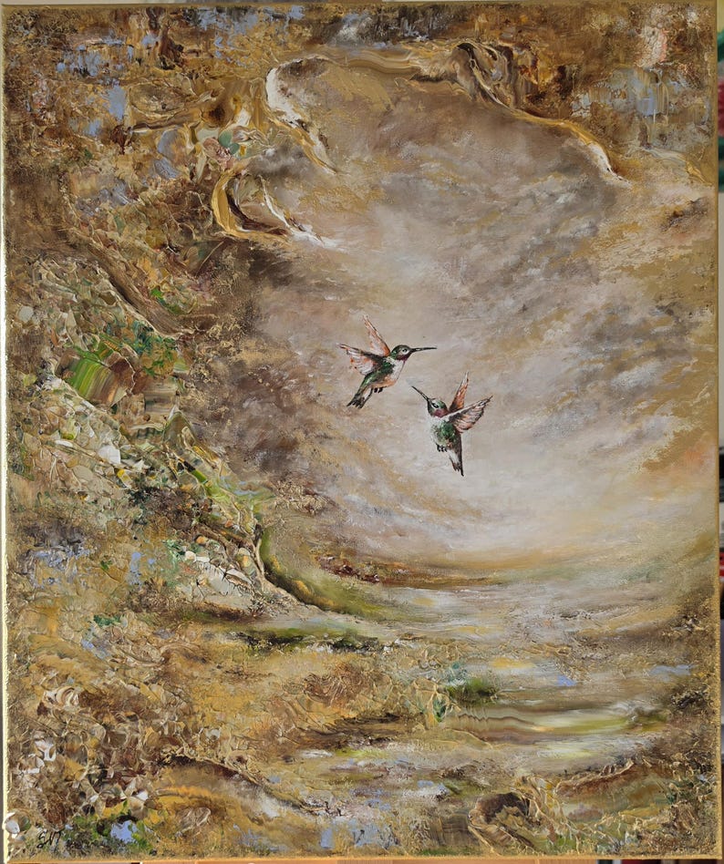 May include: An oil painting on canvas featuring two hummingbirds in flight against a textured, abstract background of swirling gold, brown, and cream tones. The birds display iridescent green and red plumage, set within a gold-toned frame.
