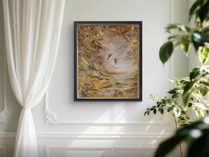 May include: A rectangular framed painting featuring two small birds in flight against a textured, abstract background of swirling golden, brown, and cream tones. The artwork is enclosed in a dark, thin frame, showcasing a layered, impasto-style application of paint that creates depth and movement across the canvas surface.