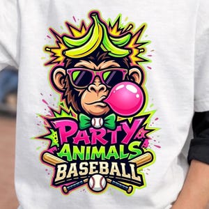 May include: White t-shirt with a colorful graphic of a monkey wearing sunglasses, a bow tie, and blowing a bubble. The text "PARTY ANIMALS BASEBALL" is below the monkey, with baseball bats and a baseball. The shirt has black sleeves.