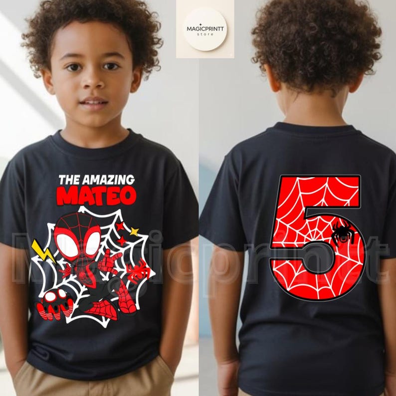 May include: Black t-shirt featuring a cartoon Spider-Man design with the text "THE AMAZING MATEO" on the front. The back of the shirt displays a large red number "5" with a spider web pattern and a spider graphic. The shirt is for a child.