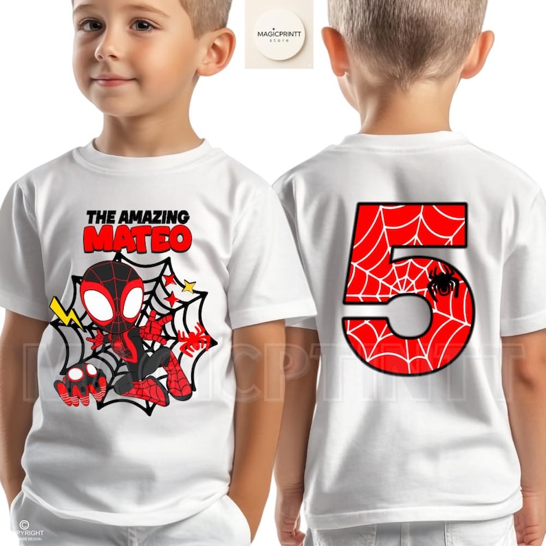 May include: White t-shirt featuring a cartoon Spider-Man design with the text "THE AMAZING MATEO" on the front. The back of the shirt displays a large red number 5 with a spiderweb pattern and a spider.