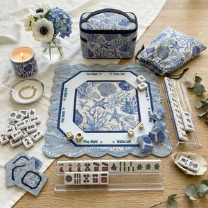 Complete 4-piece American mahjong gift set in blue and white ocean print — includes choice of square or scalloped mahjong mat with rules, custom-back mahjong tiles, acrylic card holders, and a zippered tile bag in coordinating coral and shell design. A stunning mahjong gift for 50th or 80th birthdays.