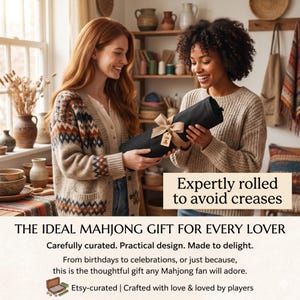 Puede incluir: Dos personas sostienen un objeto negro enrollado, atado con una cinta y una etiqueta. El texto dice "Expertly rolled to avoid creases" y "THE IDEAL MAHJONG GIFT FOR EVERY LOVER". La imagen sugiere un regalo para los entusiastas del Mahjong.