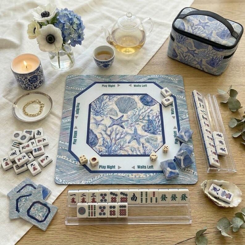 Complete 4-piece American mahjong gift set in blue and white ocean print — includes choice of square or scalloped mahjong mat with rules, custom-back mahjong tiles, acrylic card holders, and a zippered tile bag in coordinating coral and shell design. A stunning mahjong gift for 50th or 80th birthdays.