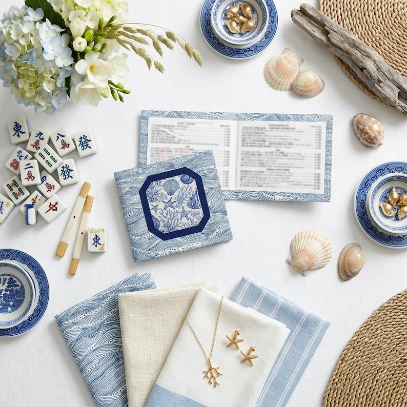 Acrylic mahjong card holder with line finder alongside a blue and white shell-print mahjong card sleeve — a mahjong card cover designed for NMJL American mahjong cards. Part of the fully coordinated blue and white coastal mahjong gift bundle.