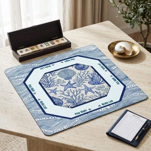 Elegant coastal decor mahjong accessories showcasing a nautical blue and white wave pattern. This aesthetic mahjong mat features beautiful illustrations of starfish and sea coral to complement a beach house or modern home interior.