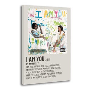 May include: A framed poster featuring the album art for "I AM YOU" by YNW Melly. The artwork displays two people in a colorful, graffiti-style design with the album title and tracklist below. The poster is on a white background.
