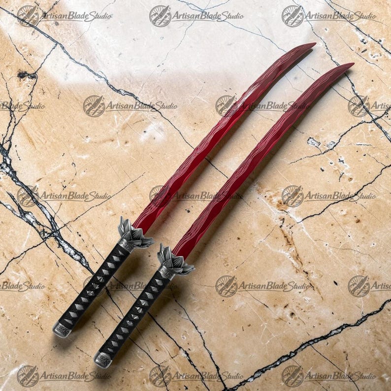 May include: Two swords with deep red blades featuring a wavy hamon line pattern. Each sword has a black handle with a silver-toned lotus-shaped tsuba guard. The blades are long and curved, extending from the ornate metal hilts to sharp points.