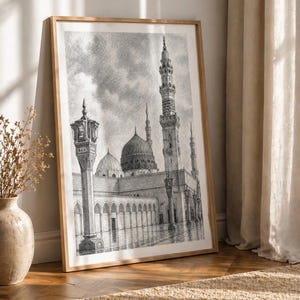 Könnte beinhalten: Gerahmte schwarz-weiße Architekturzeichnung einer Moschee mit großer Kuppel und Minaretten. Das Kunstwerk lehnt an einer Wand auf einem Holzboden, mit einer Vase mit Trockenblumen und einem Teppich im Vordergrund.