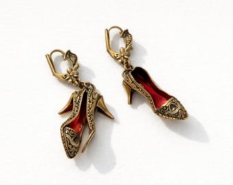 Vintage-inspired high heel dangle earrings with gold tone metal and red interior detail.