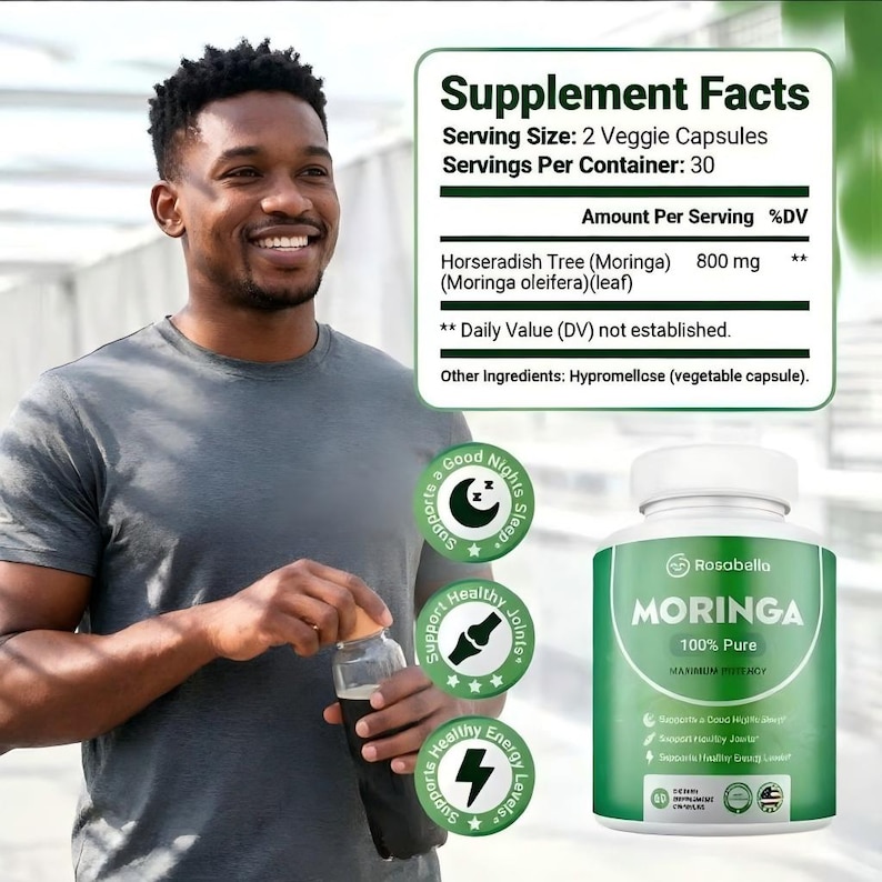 May include: A man smiles while holding a bottle and a bottle of Rosabella Moringa capsules. The green and white bottle has the text "MORINGA 100% Pure" and supports healthy joints, energy levels, and good nights sleep.