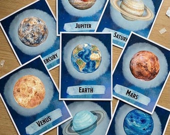 Può includere: Un set di carte didattiche sui pianeti con illustrazioni ad acquerello dei pianeti del sistema solare. Ogni carta mostra un pianeta con il suo nome: Mercurio, Venere, Terra, Marte, Giove, Saturno, Urano e Nettuno. Sfondo blu.