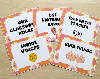 Può includere: Un set di cinque schede delle regole della classe con un bordo floreale. Ogni scheda presenta una regola diversa: "Le nostre regole della classe", "Usa le orecchie che ascoltano", "Occhi sull'insegnante", "Voci interiori" e "Mani gentili". Le schede hanno uno sfondo bianco con testo nero e illustrazioni colorate.