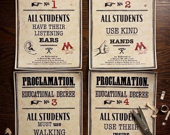 Può includere: Quattro poster rettangolari in carta intitolati Proclamation Educational Decree No. 1, 2, 3 e 4. Ognuno presenta testo nero su sfondo beige con numerazione rossa, illustrazioni di un orecchio, mano, scarpa e dito sulle labbra, e un logo M rosso.