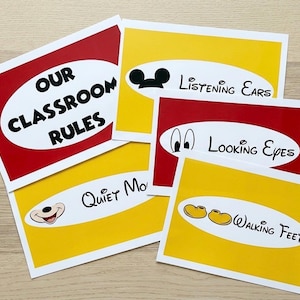May include: A set of classroom rule cards with a red and yellow color scheme. The cards feature text such as "Our Classroom Rules", "Listening Ears", "Looking Eyes", "Quiet Mouth", and "Walking Feet". The cards have a white border.