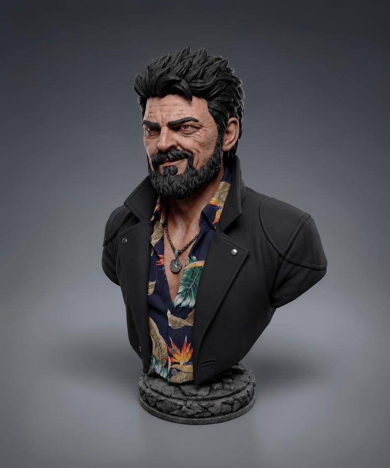 May include: A detailed bust of a bearded character with dark, textured hair, wearing a black jacket over a dark blue shirt featuring a colorful tropical floral print. A silver-toned pendant necklace hangs around the neck, and the figure is mounted on a circular, stone-textured base.