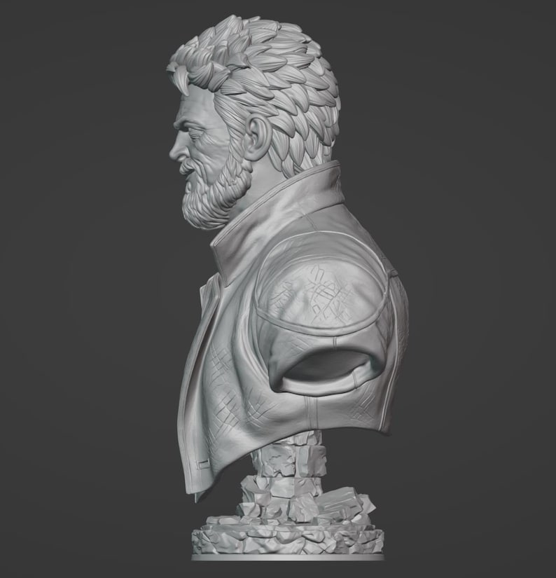 May include: A monochromatic gray bust sculpture depicting a side profile of a bearded individual with textured, layered hair. The figure wears a collared jacket with visible shoulder detailing, resting on a base composed of stacked, irregular stone blocks.
