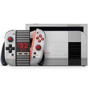 Puede incluir: Una consola Nintendo Switch con un diseño retro, con una combinación de colores gris y blanco con detalles en rojo. Los mandos tienen una disposición de botones clásica y la consola tiene el texto "Nintendo Switch".