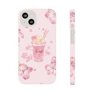 May include: Pink phone case featuring a floral design with cherry blossoms and a milkshake illustration. The milkshake has whipped cream, a flower, and the word "Sweet" written on the cup. The case is shown from the front and side.